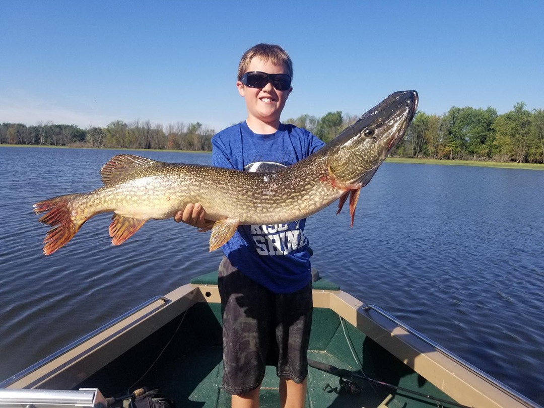 Boy on boat holding fish