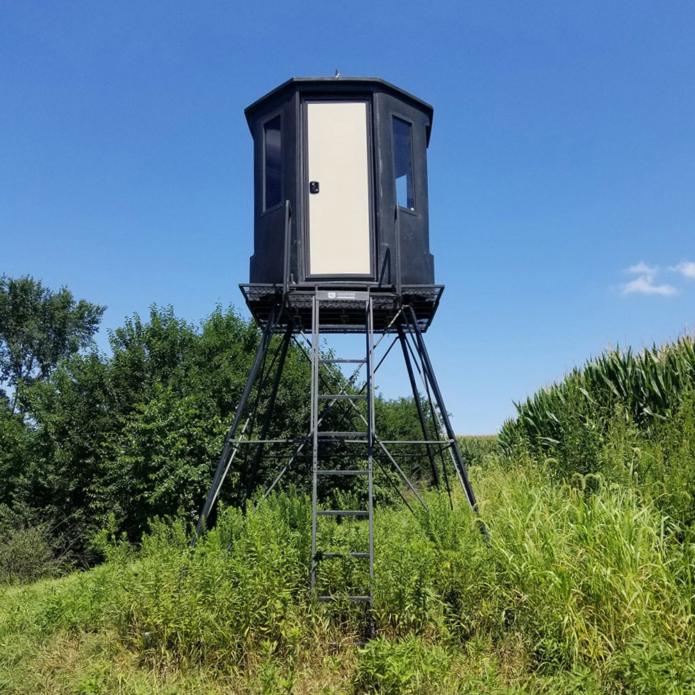 Hunting blind mounted on deer stand tower on hillside