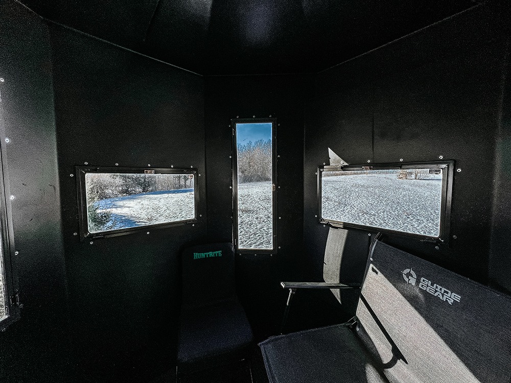 Interior of hunting blind with vertical bow window and horizontal sliding windows